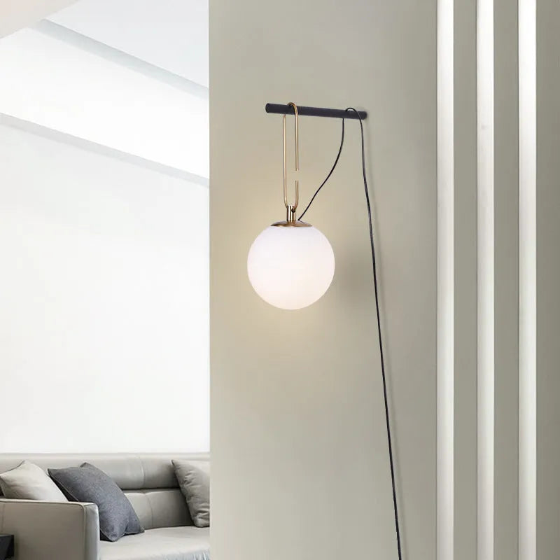 Modern Nordic-style glass wall lamp on a white wall, showing clean lines and translucent glass construction.