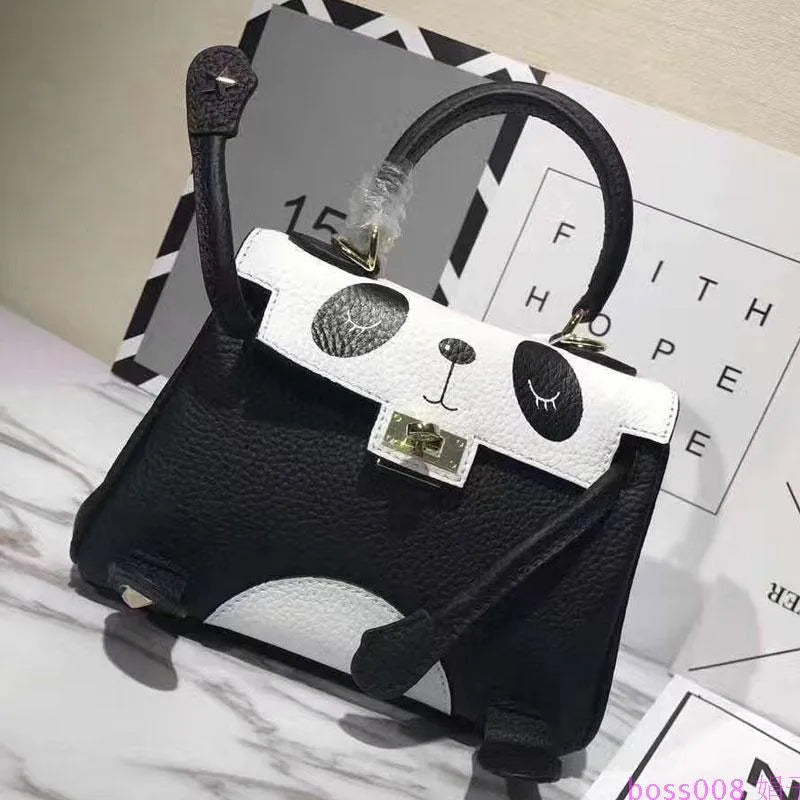 Black and white panda print on a structured horizontal square cowhide leather handbag with top handles.