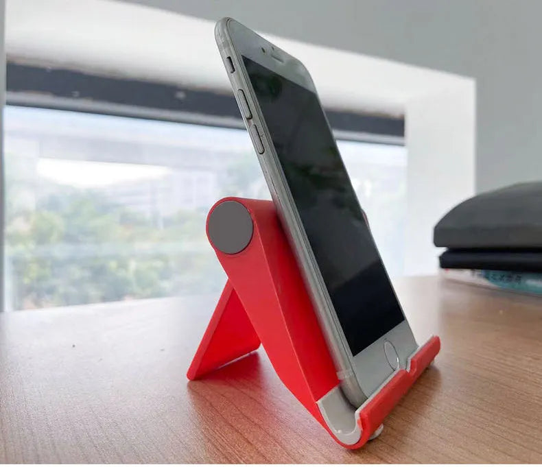 PE folding mobile phone stand in black on a wooden desktop, holding a tablet.