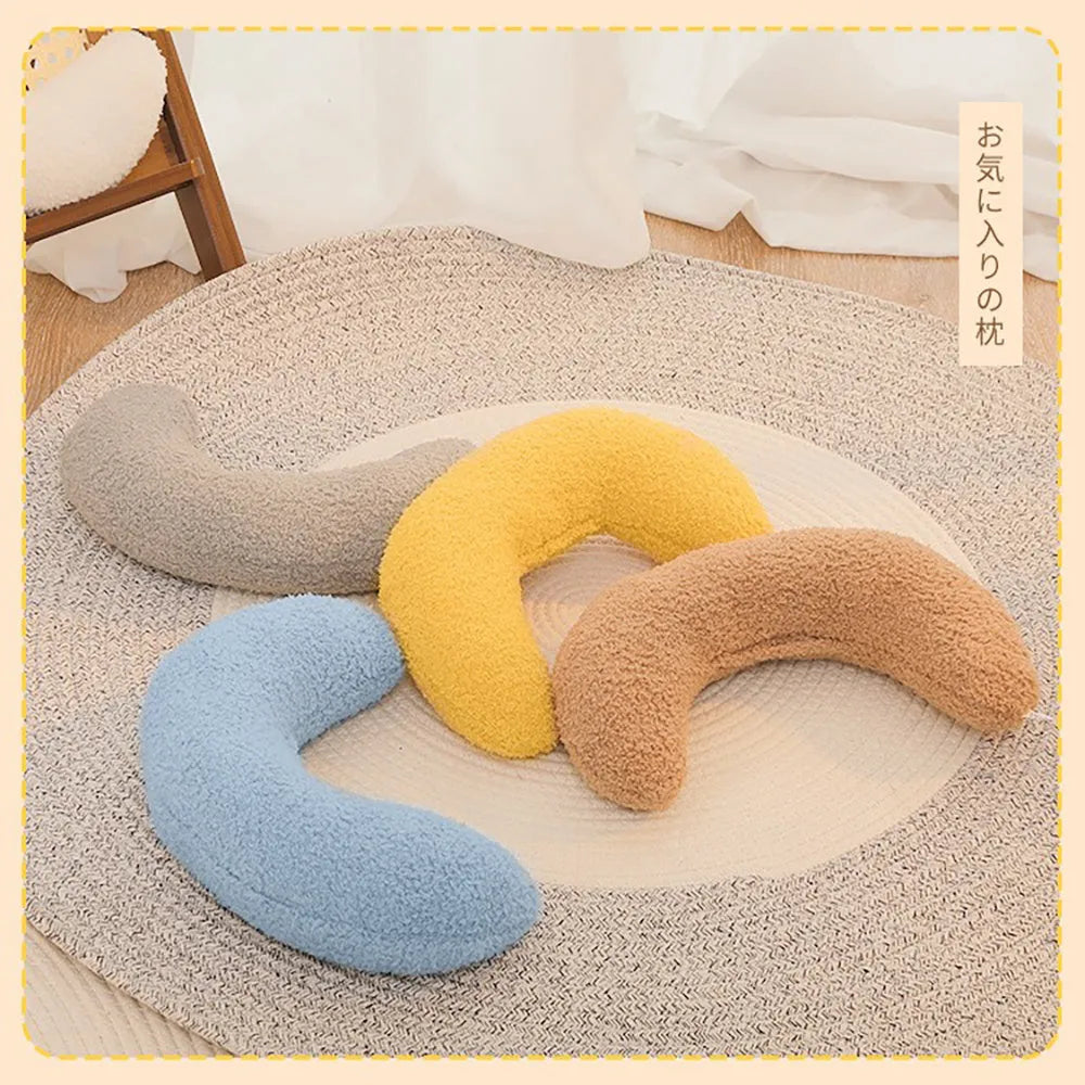 U-shaped blue cat pillow with adjustable collar placed on a sofa