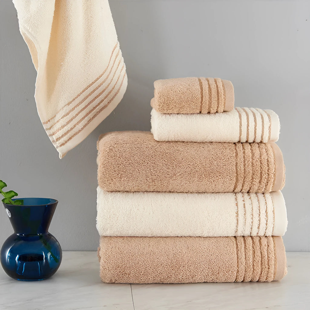 Cotton towel set in brown or beige showing bath sheet, hand towel, and face cloth sizes