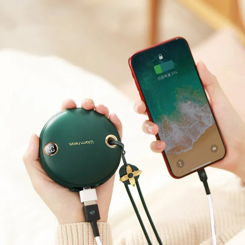 Green 5000mAh power bank hand warmer with digital display shown next to its charging cable.