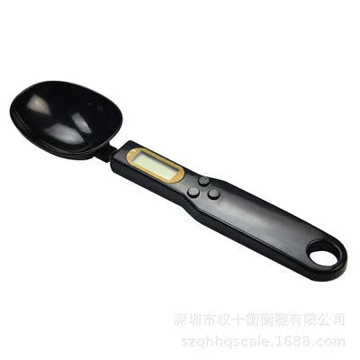 White digital spoon kitchen scale with LCD screen showing weight measurement.