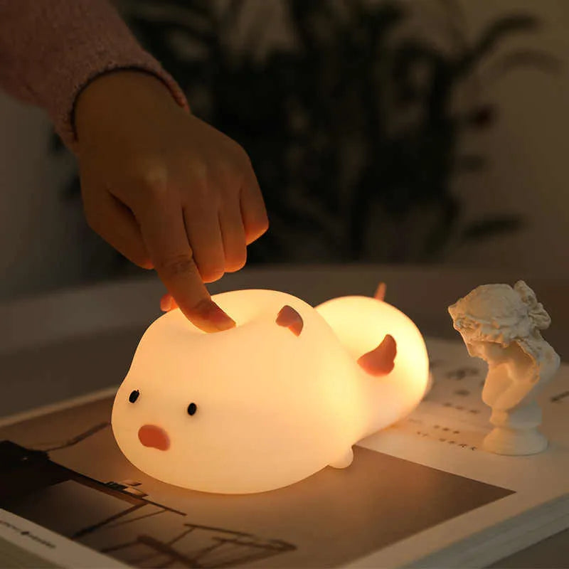 Blue or pink pig silicone night light with sleeping design, shown with dimensions and rechargeable battery.