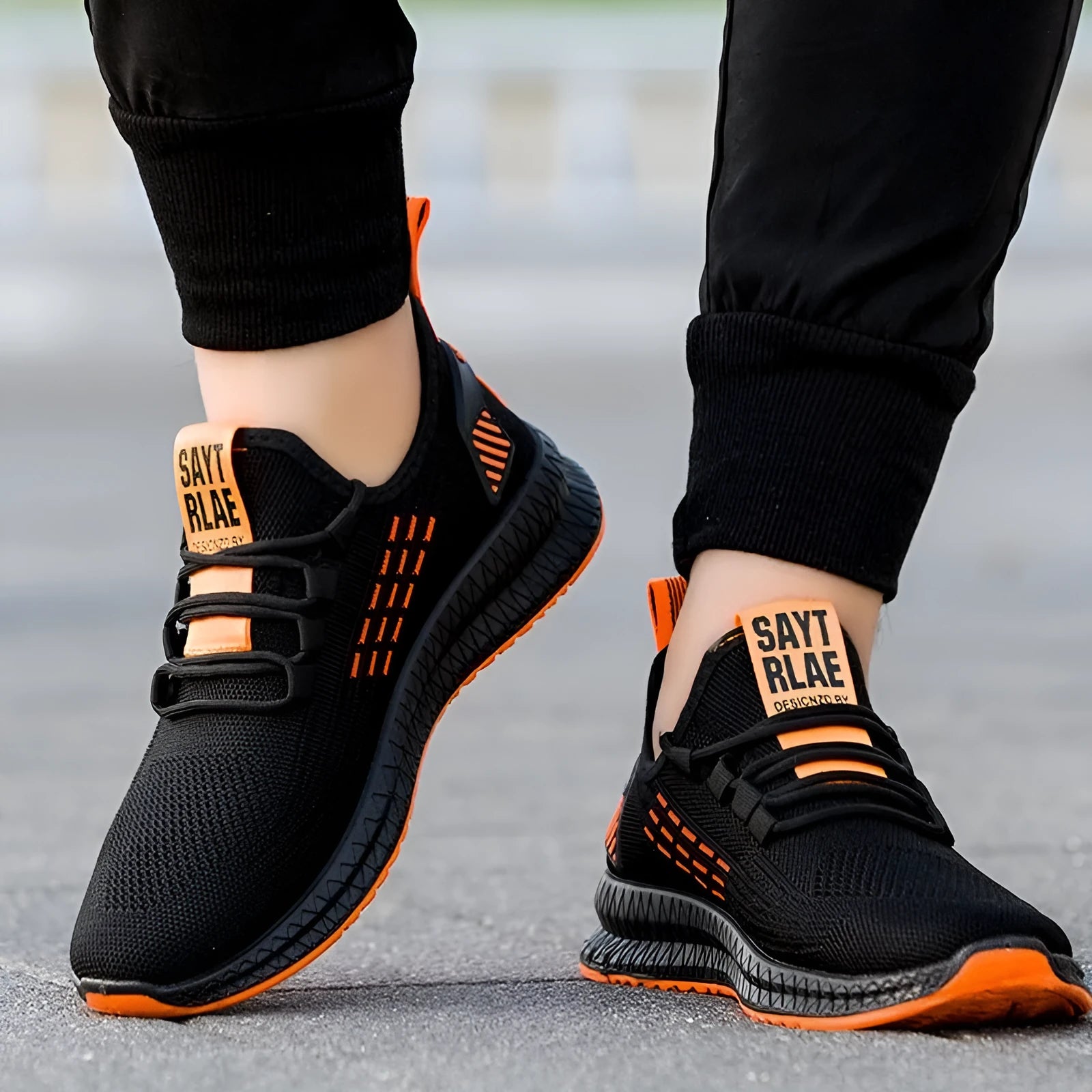 Men's black sports casual trainers with cross strap detail and flying weave textile upper
