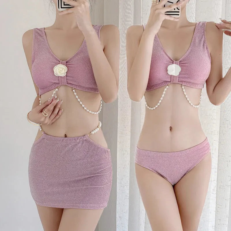 Pink and black three-piece bikini set on a hanger, showing briefs style and sleeveless design.