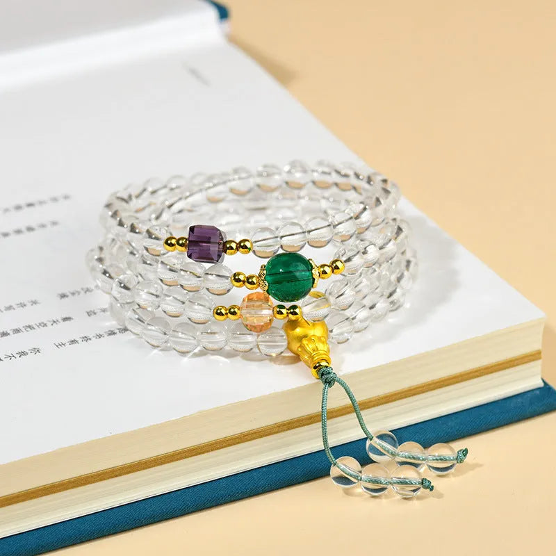 White crystal 108-bead rosary necklace and matching bracelet set on a plain background