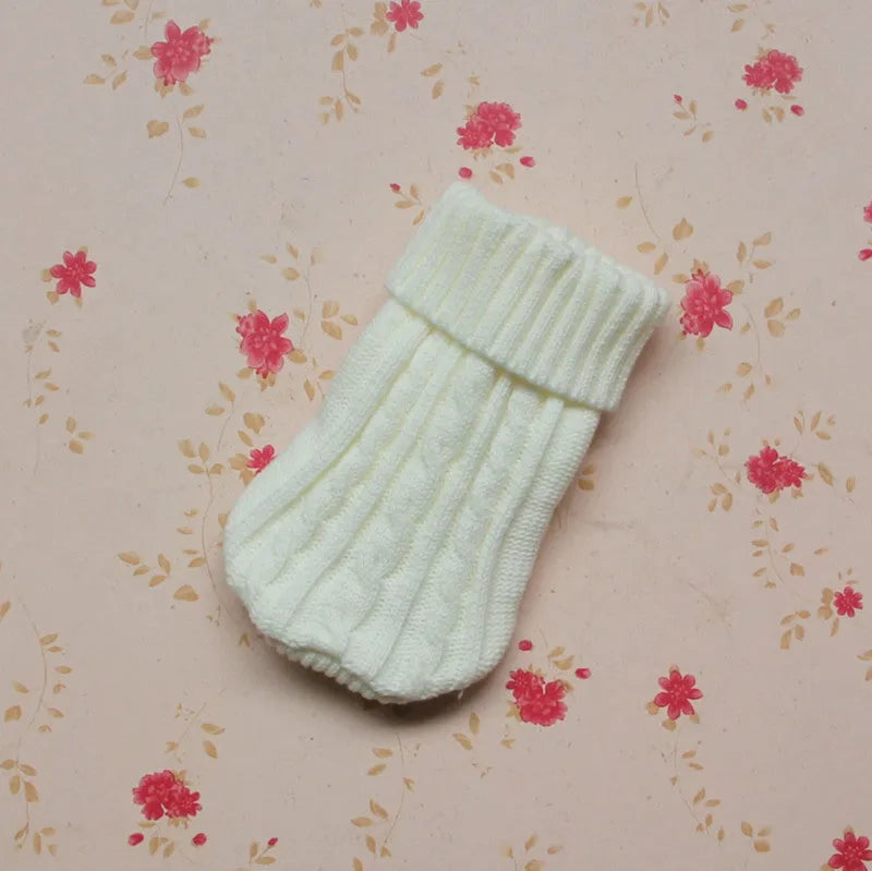 Knitted wool dog sweater with fabric buttons on a white background, shown in blue