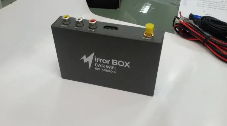 Black car mirror link box with power cable, AV cable, antenna, and user manual.