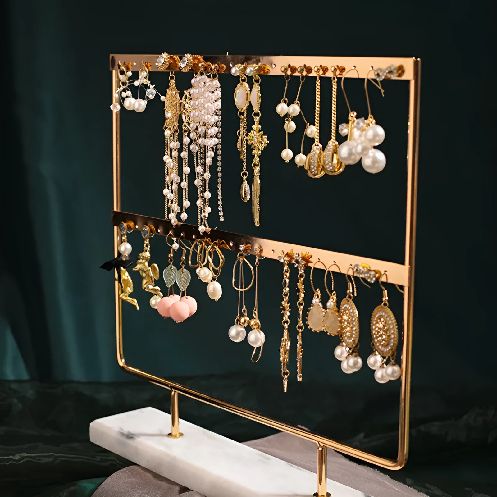 Alloy earring storage rack in green on a desktop holding multiple stud and hook earrings