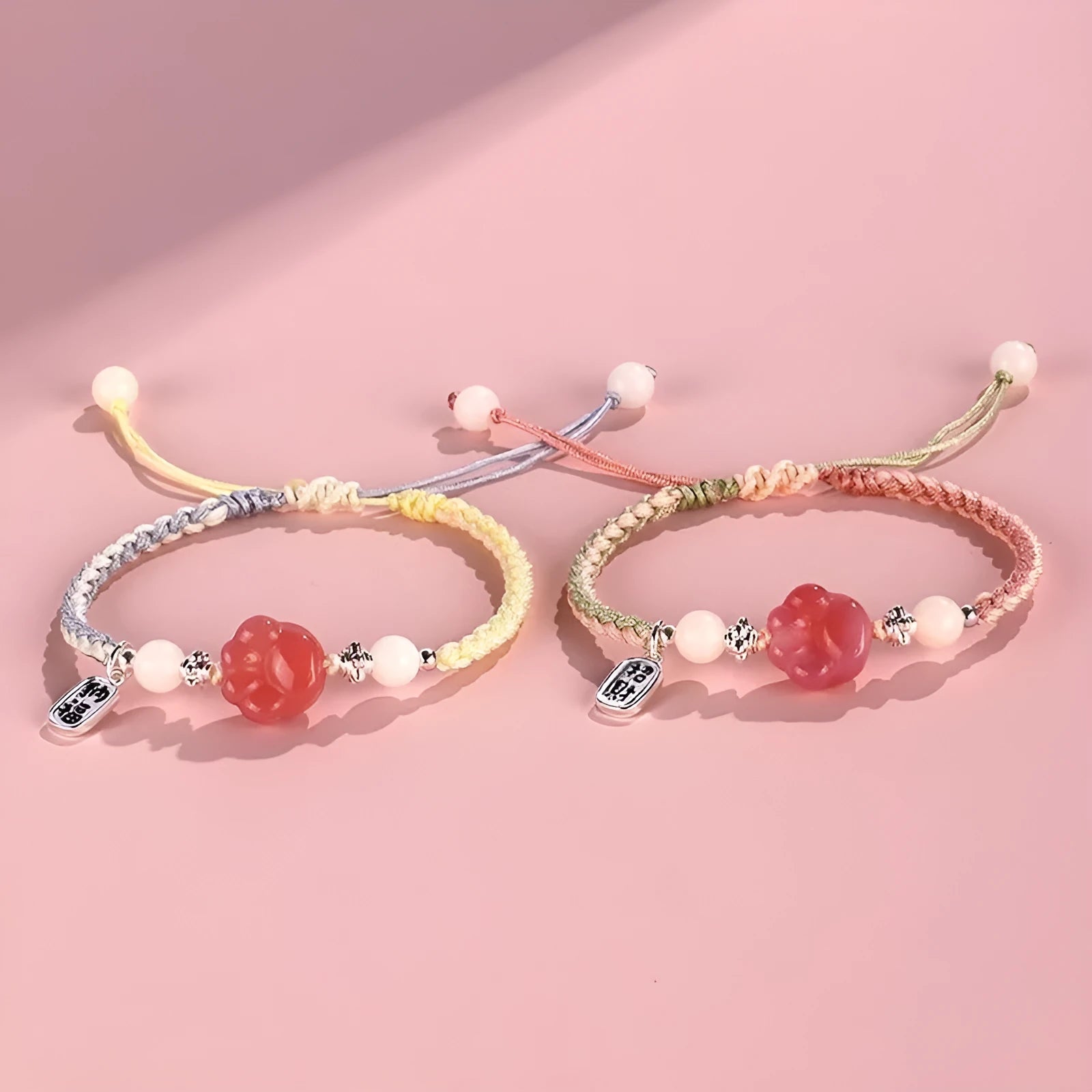 Red cat's paw charm couples bracelet with pink woven base, handmade glass and glaze jewellery