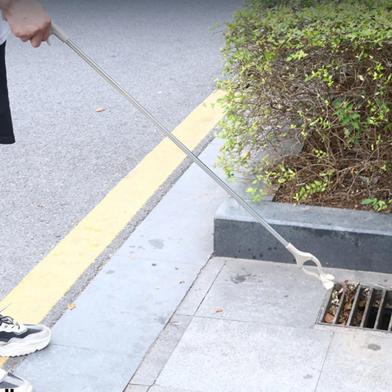 Stainless steel garbage picker with extended 40cm arm and plastic handle.