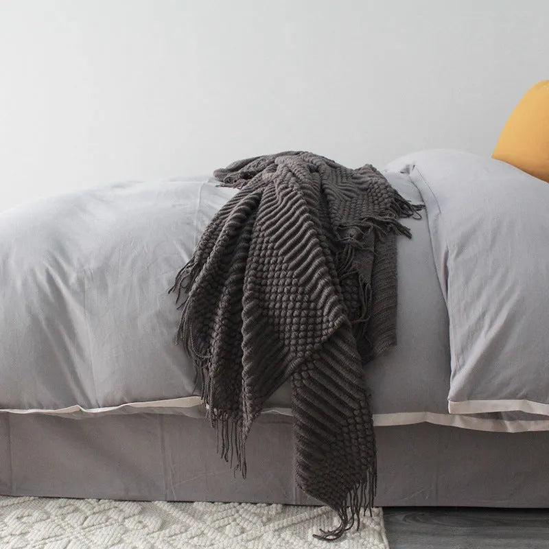 Small rectangular polyester nap blanket in dark grey, khaki, and light grey colours, measuring 127 by 170 cm.