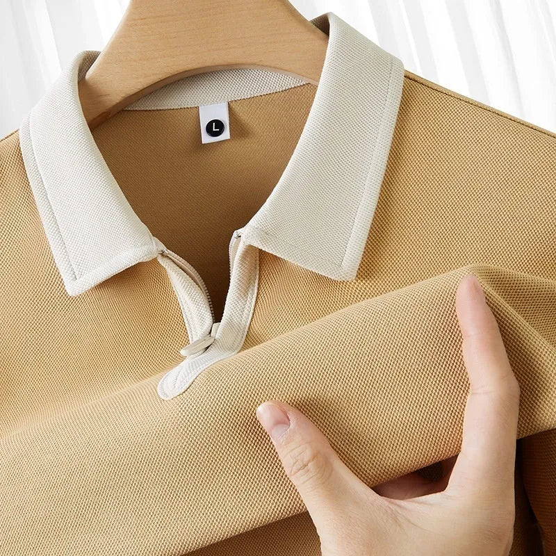 Man wearing a solid colour polo shirt with a zip-up lapel collar and short sleeves.