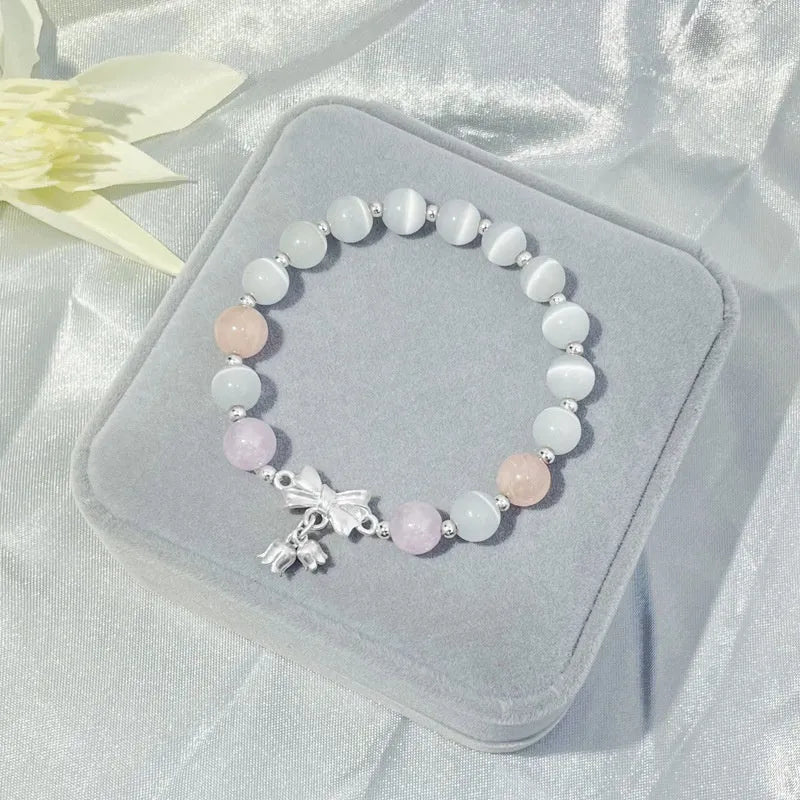 Lavender amethyst opal bracelet with a silver-toned bowknot design on a wrist.