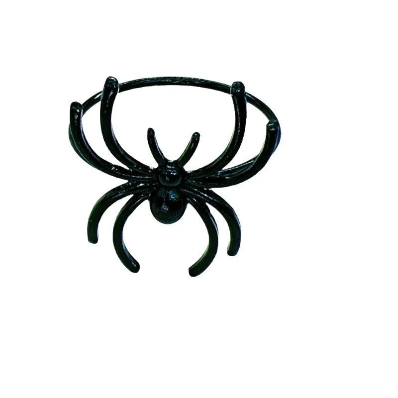 Set of six black alloy Halloween napkin rings with detailed spider design on a table setting.