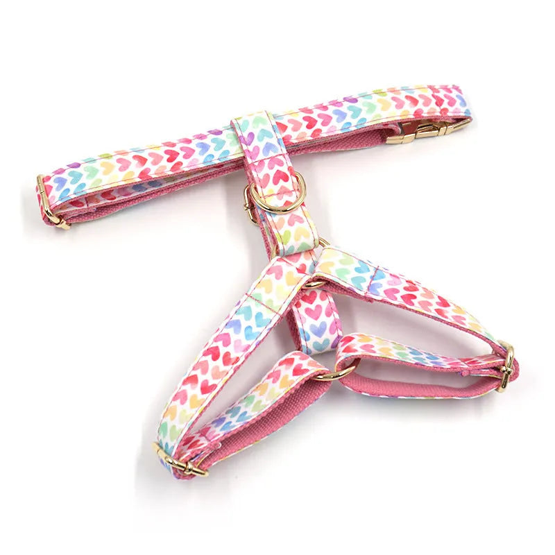 Pink dog harness with gold buckle and colourful heart-shaped stone decoration in four adjustable sizes