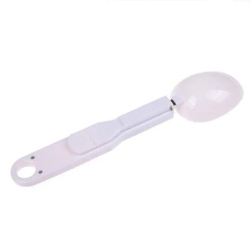 White digital spoon kitchen scale with LCD screen showing weight measurement.