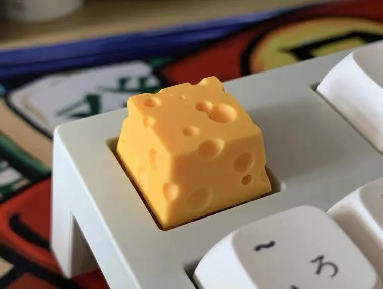 Yellow solid resin artisan key cap sculpted like a piece of cheese for mechanical keyboards.