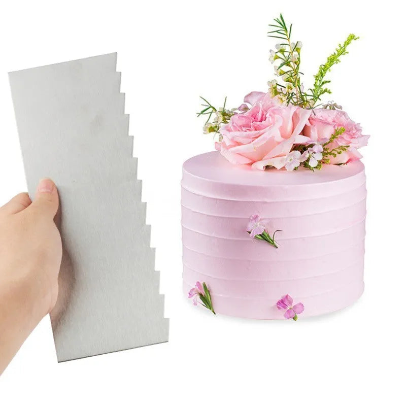 Stainless steel cake decorating scraper with a patterned polygon edge on a kitchen worktop.