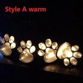 Black solar-powered animal paw print LED garden lights with four paw shapes connected to central solar pole