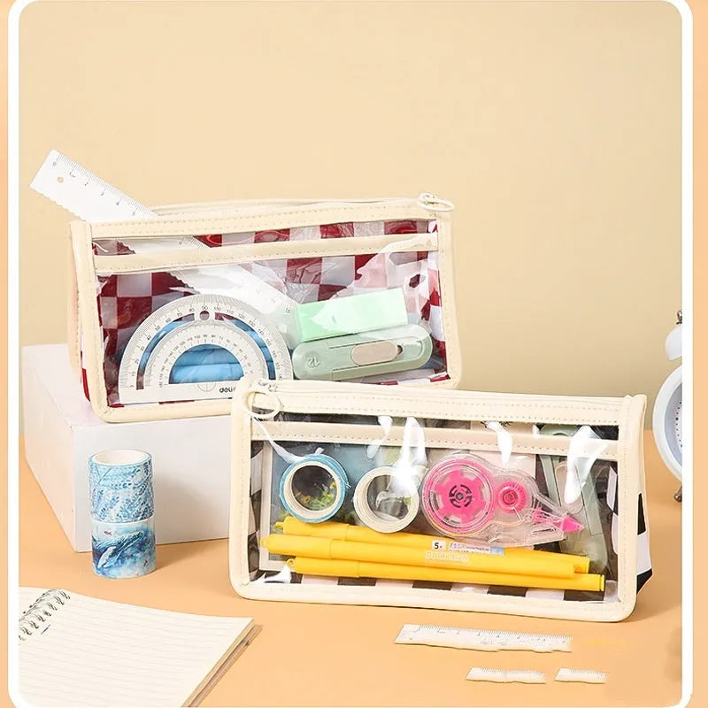 Transparent PVC pencil case with chessboard grid pattern, showing pens inside.