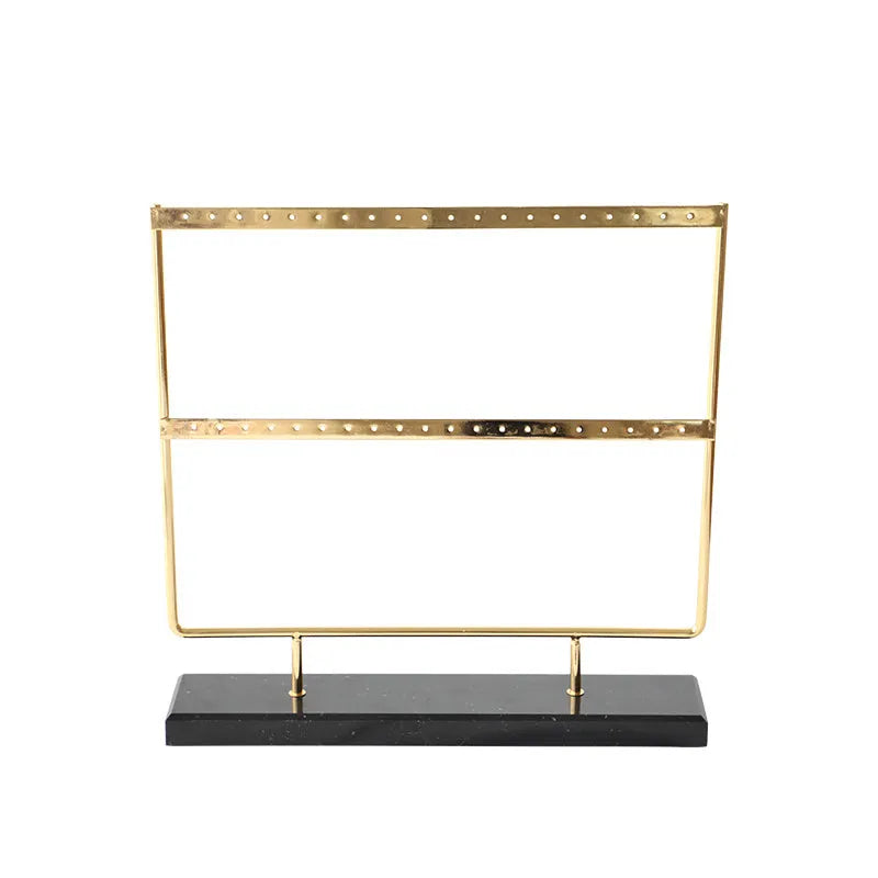 Alloy earring storage rack in green on a desktop holding multiple stud and hook earrings