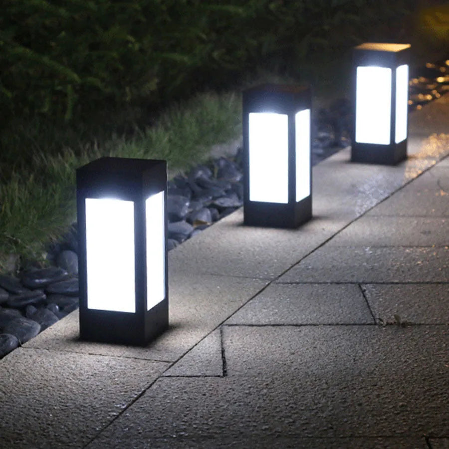 Set of solar-powered LED garden lights in various styles illuminating an outdoor patio at dusk.