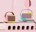 Pink Bluetooth speaker and microphone combo with coloured LED lights illuminated, placed on a table.