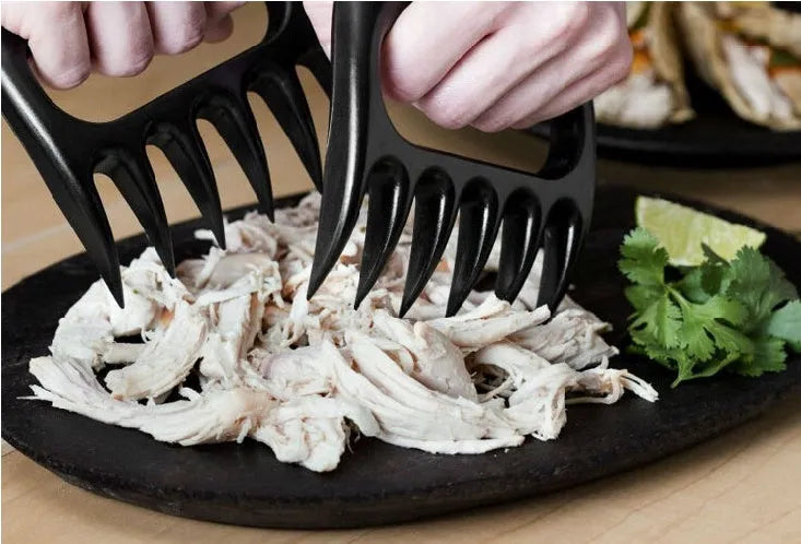 Two black bear claw meat shredder forks for pulling pork and BBQ preparation.