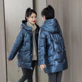 A woman's loose-fit hooded winter jacket in a poly-cotton blend, shown in a choice of colours including black and champagne.