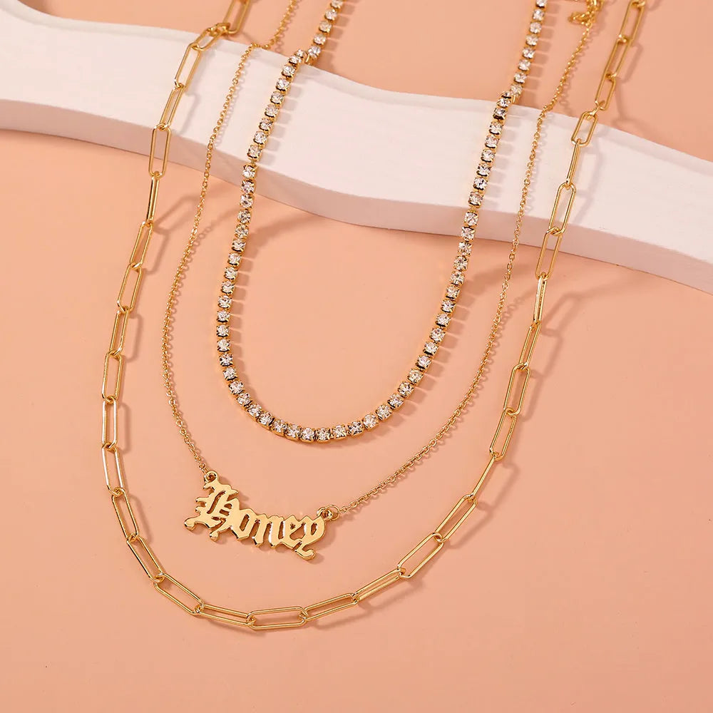 Monogram pendant multi-layer necklace on display showing electroplated zinc alloy chain and personalised initial
