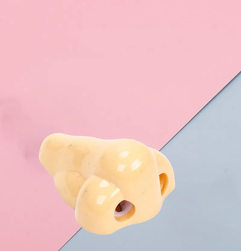 Flesh-coloured plastic manual pencil sharpener with a geometry shape and large nostril.