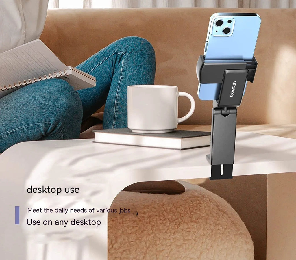A black foldable phone holder with a rotating base, shown holding a mobile phone in landscape orientation.