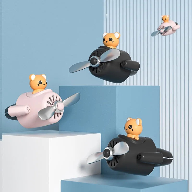 Cartoon aeroplane-shaped plastic car air vent aromatherapy diffuser with rotating fan blades.