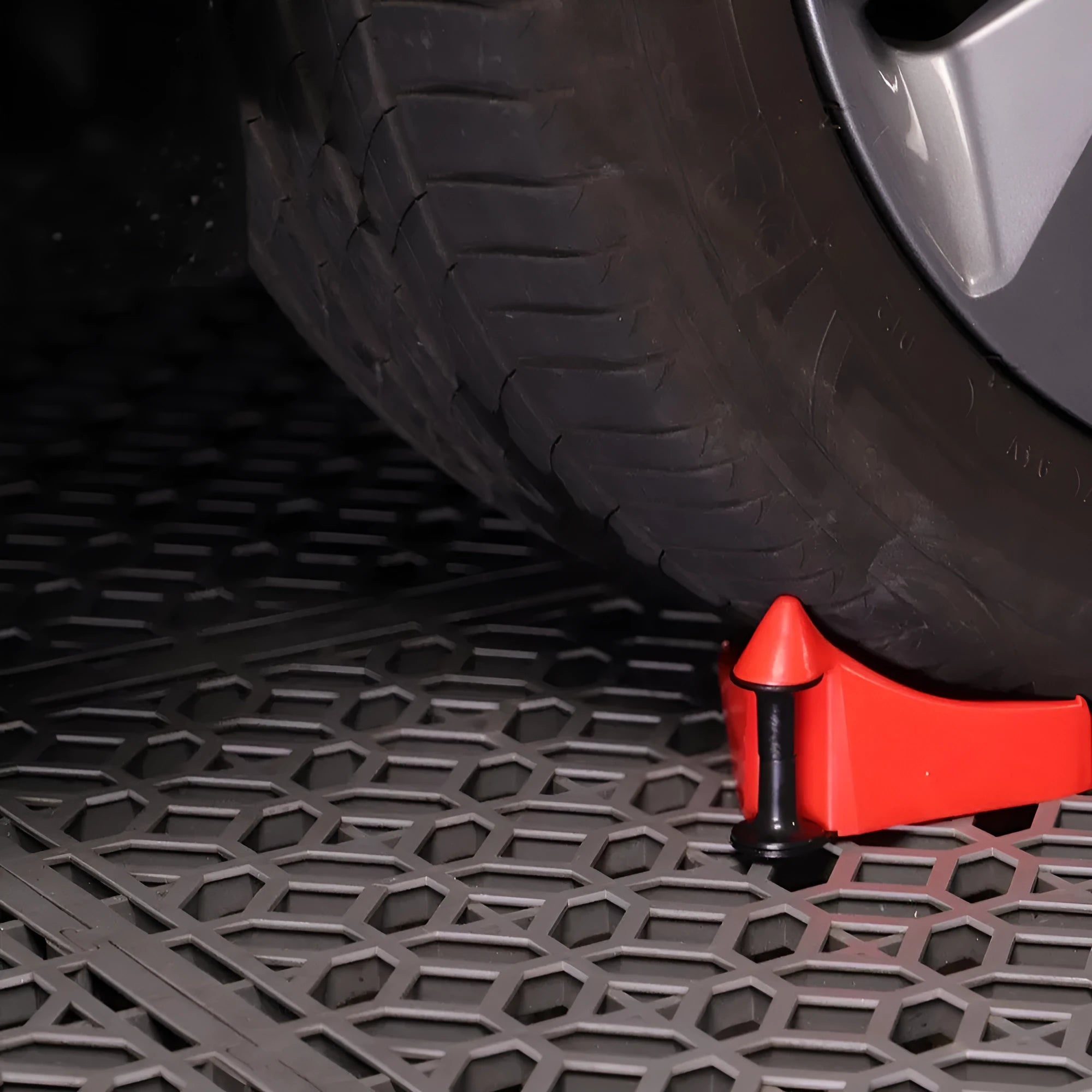 Four red triangular plastic car parking blocks with non-slip rubber surfaces