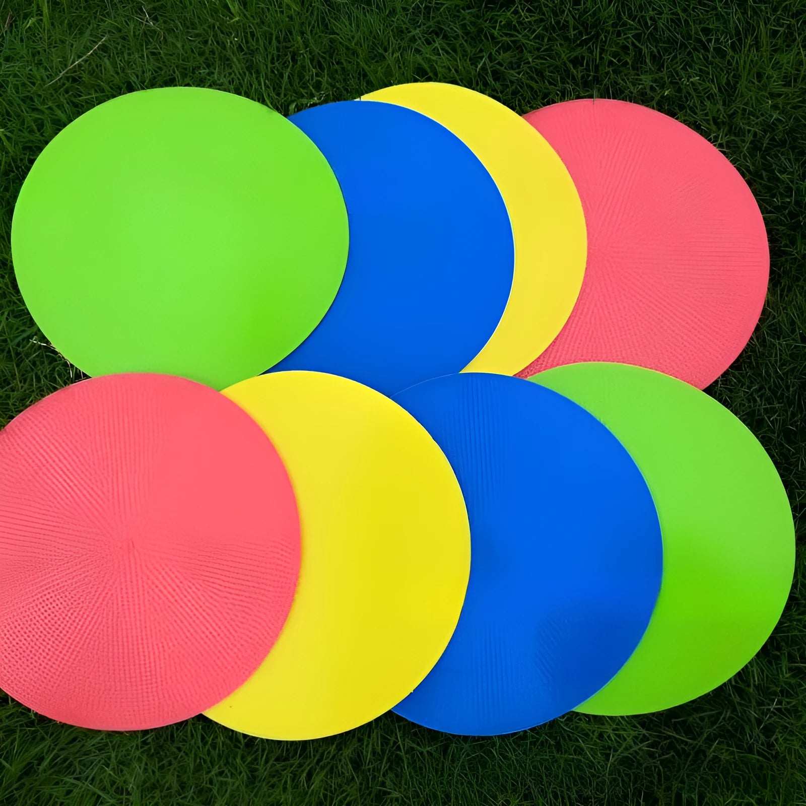 Soft yellow TPE football training target pad flat on grass, 23cm diameter.