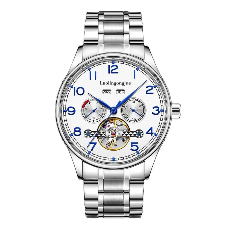 Men's stainless steel mechanical watch with leather strap and butterfly buckle on a business suit cuff.