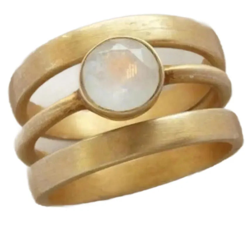 A gold-plated geometric ring with a hollow design and a small white chalcedony stone set into the band.