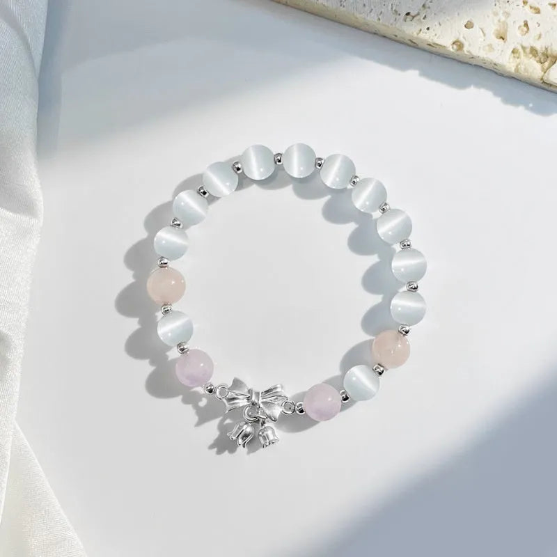 Lavender amethyst opal bracelet with a silver-toned bowknot design on a wrist.