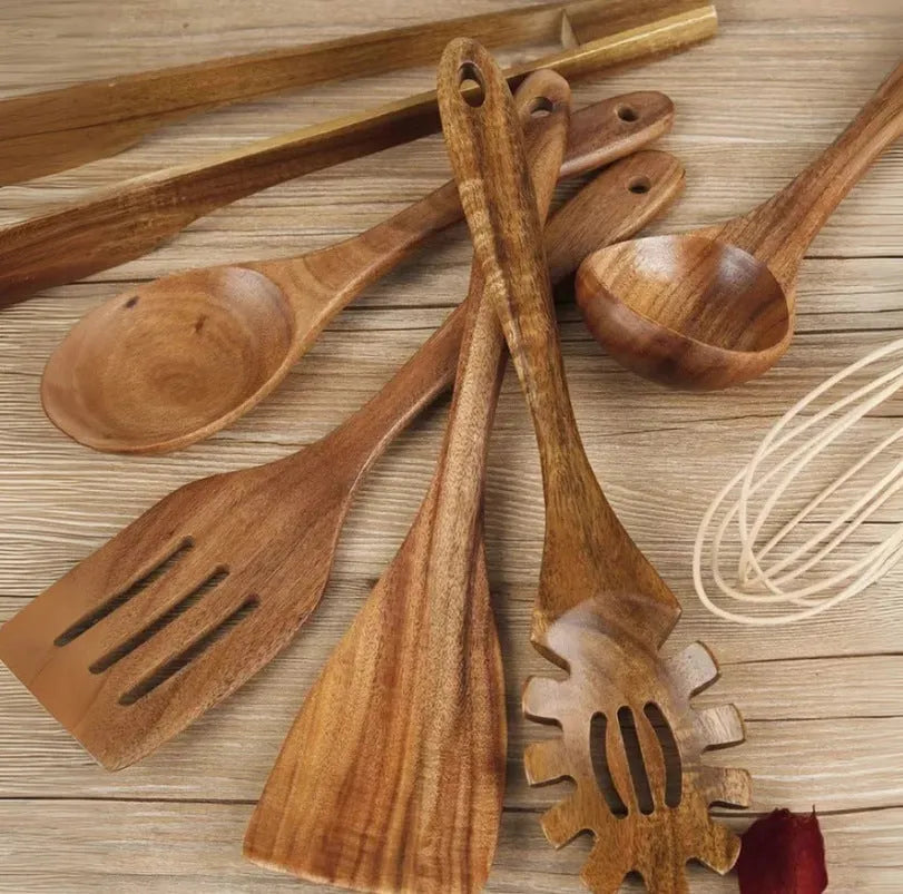 Seven wooden cooking utensils including spoons and spatulas arranged together