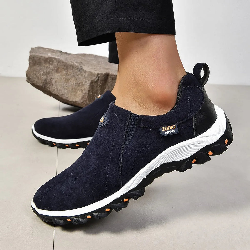 A pair of grey round-toe men's slip-on shoe covers made of PU with a rubber sole.