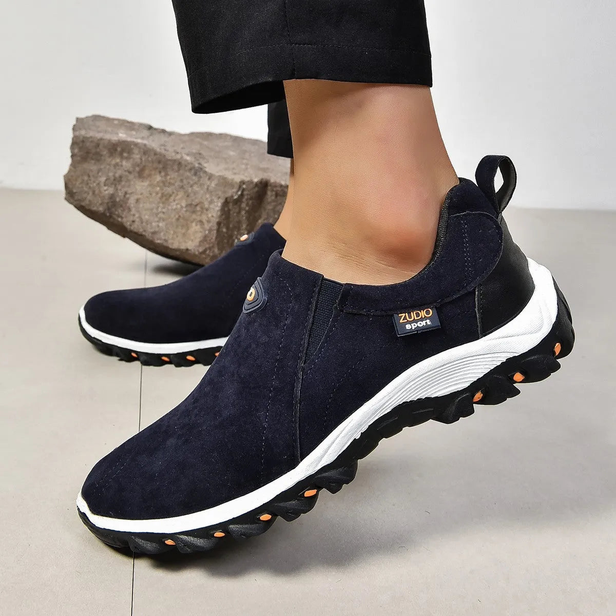 A pair of grey round-toe men's slip-on shoe covers made of PU with a rubber sole.