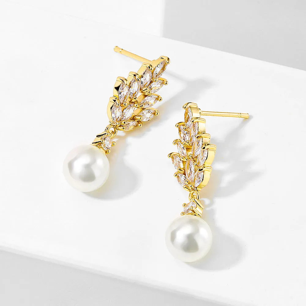 Geometric flower-shaped earrings with micro inlaid zircon and pearl details on a gold-toned metal base.