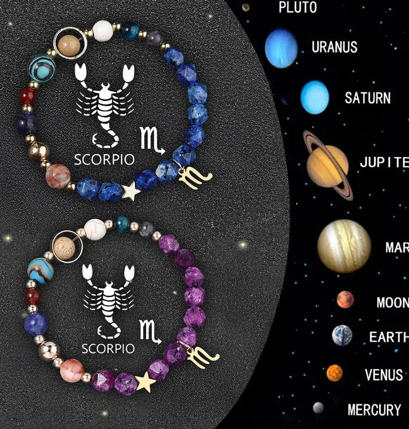 Set of twelve natural stone bead bracelets on a table, each with a different coloured gemstone representing a zodiac sign.