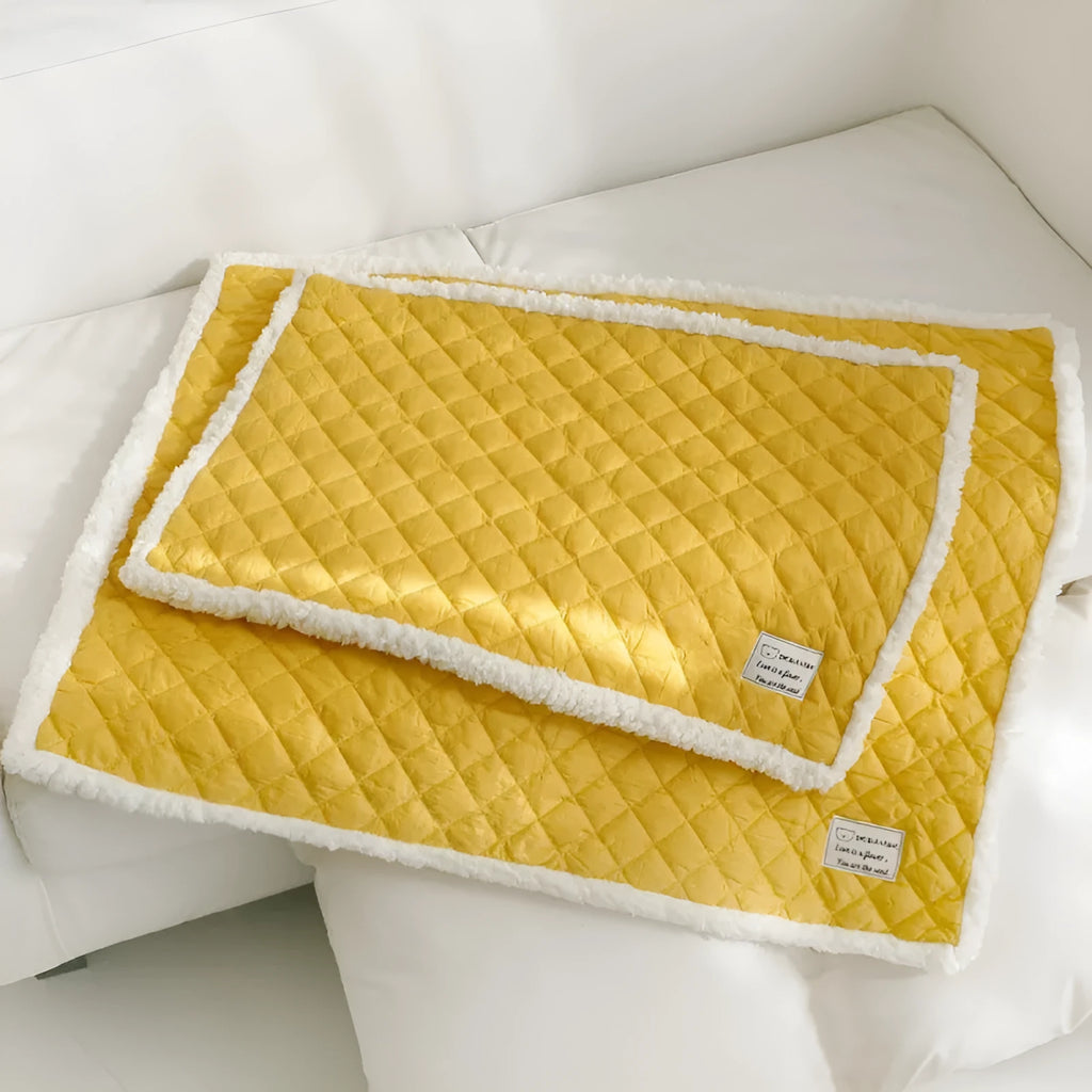 Blue quilted terry cloth cat blanket shown in a pet bed.