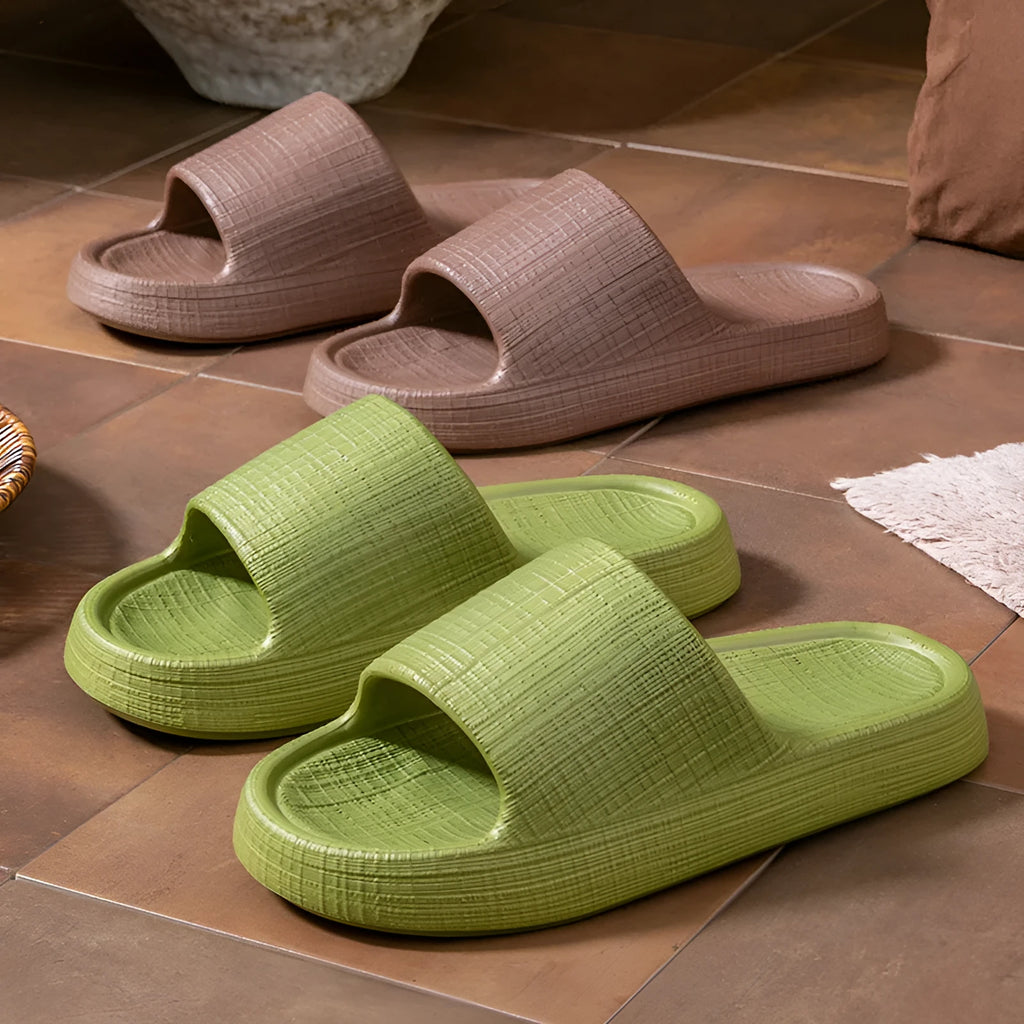 Pair of EVA toe ring flip flop slippers on a wet floor, showing non-slip sole pattern.