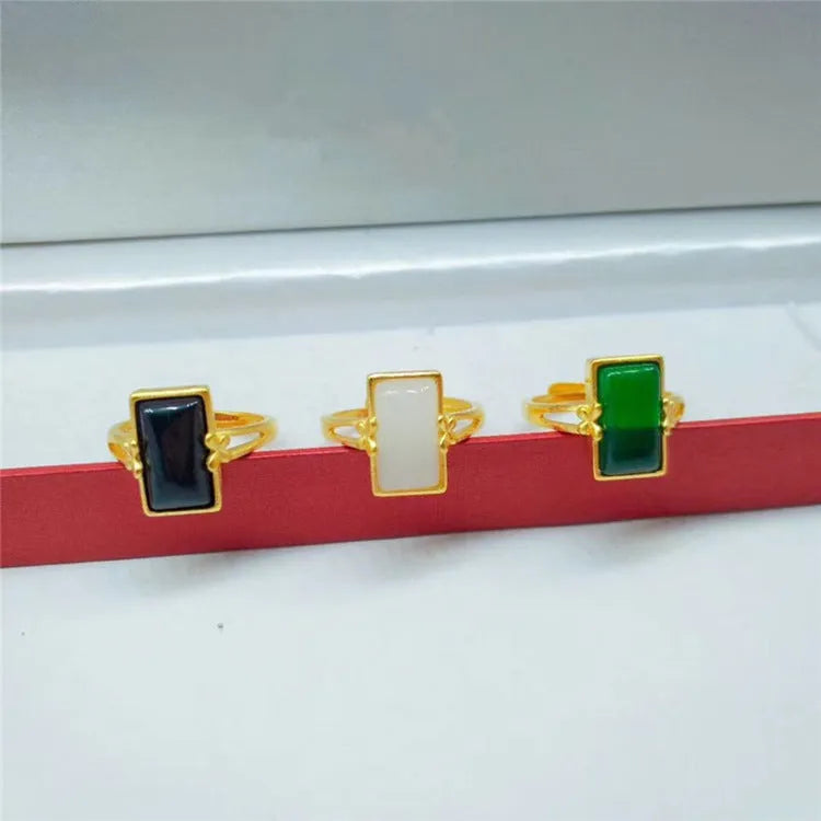 Gold-plated brass ring with an adjustable band and a central green gemstone in a national style.