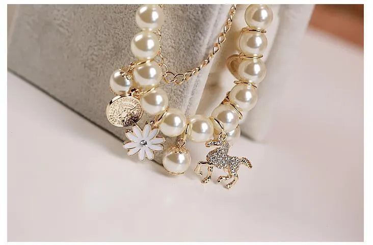 White pearl flower bracelet with simulated pearl beads, floral design, 17cm length, on a soft surface