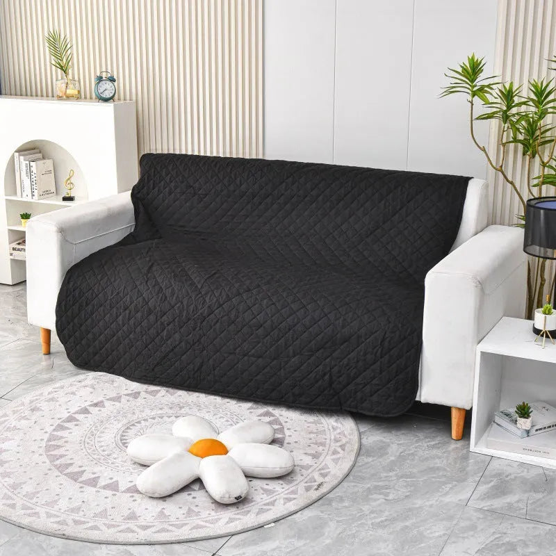 Reversible waterproof dog blanket on a sofa showing two colour sides, available in black, burgundy, camel, coffee and grey.